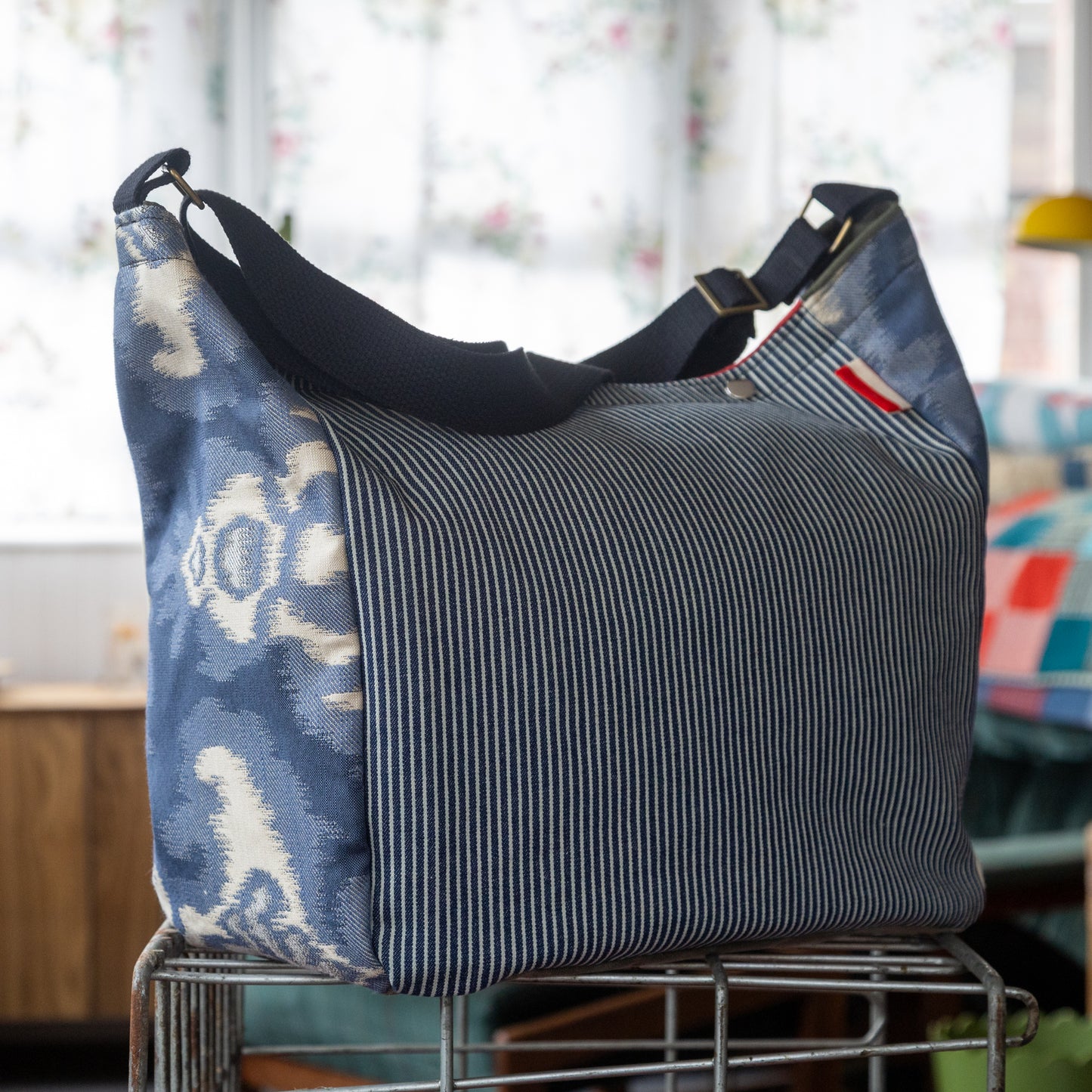Shoulder bag in hickory stripe, ikat panels, and lush red interior
