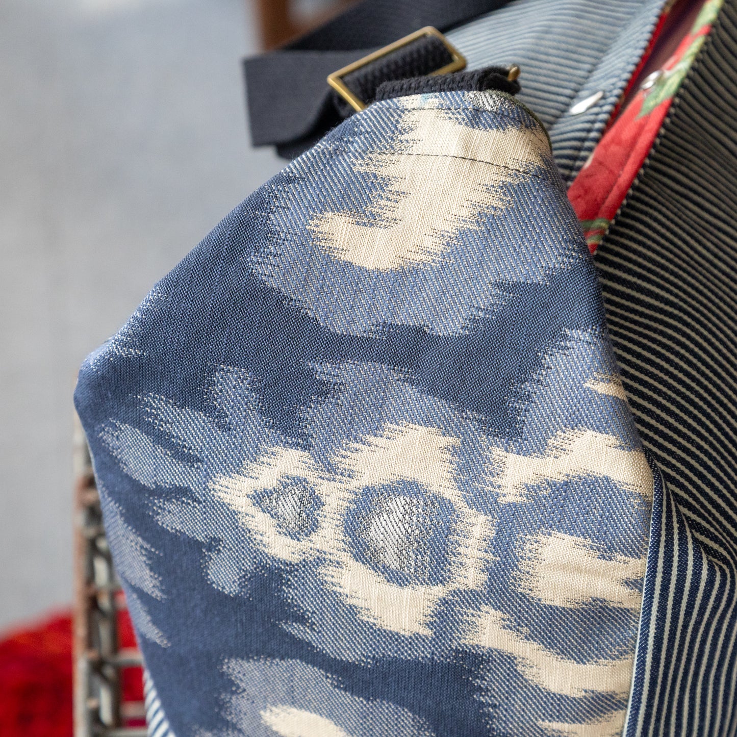 Shoulder bag in hickory stripe, ikat panels, and lush red interior